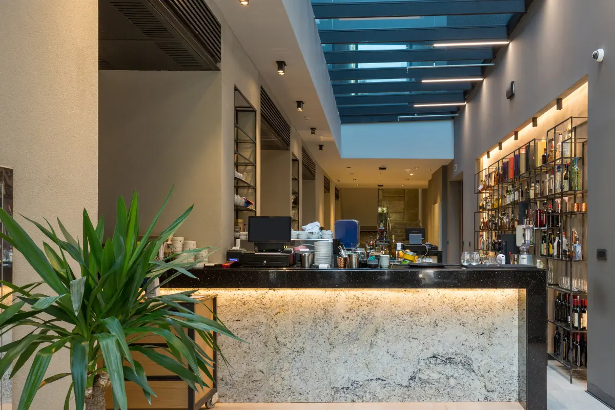 Bar moderne avec comptoir marbre blanc, bibliothèque bouteilles et plafond design